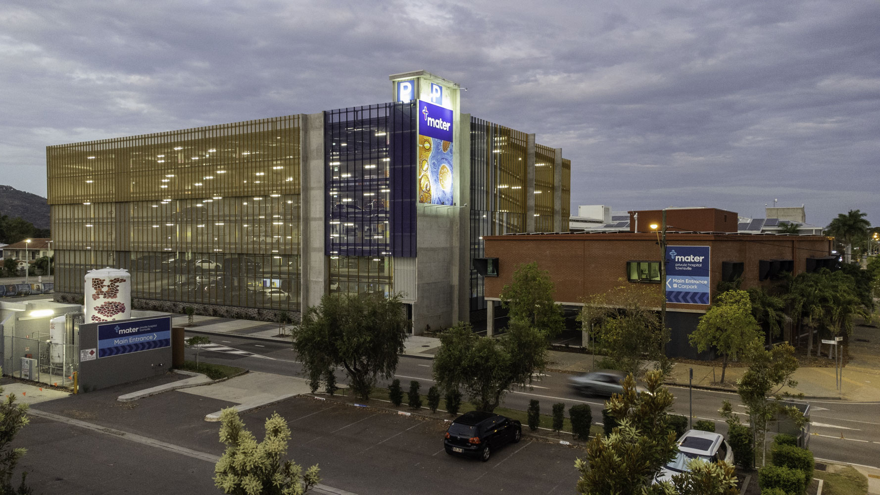 Mater Health Multi Storey Carpark Townsville Twighlight View Of Carpark With Lights And Nursing Lab On Right