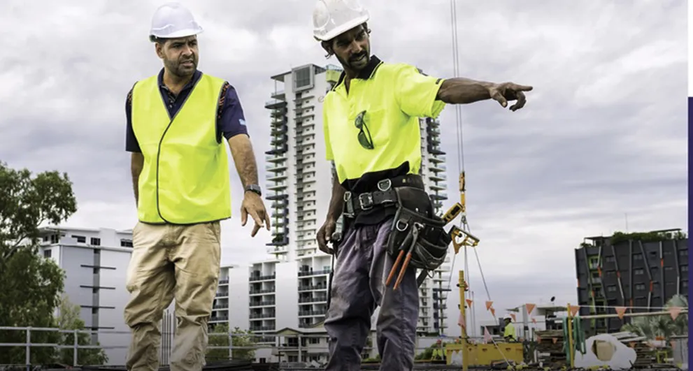 Two construction workers wearing yellow vests and hard hats working at a construction site in Territory Infrastructure Loans Financing Partnerships