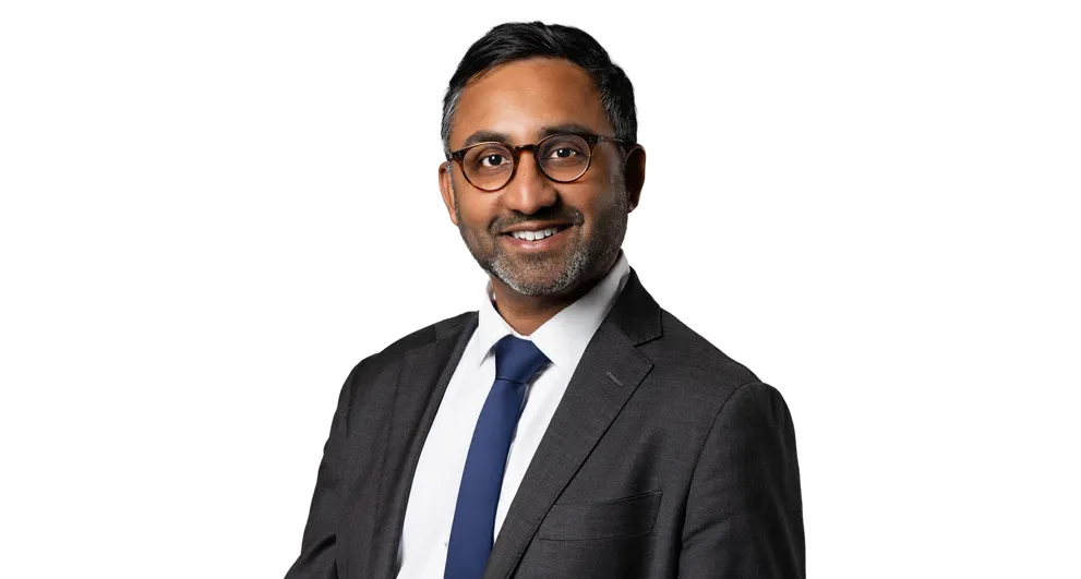 Raveen Sritharan wearing a suit and blue tie