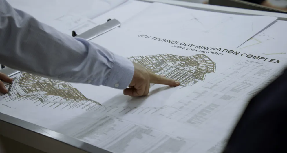 Tight View Of Besix Watpac Project Manager Pointing At Plans For JCU Engineering And Innovation Place
