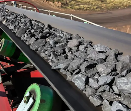Manganese ore travelling down a conveyor belt