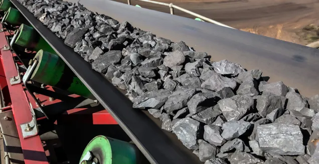 Manganese ore travelling down a conveyor belt