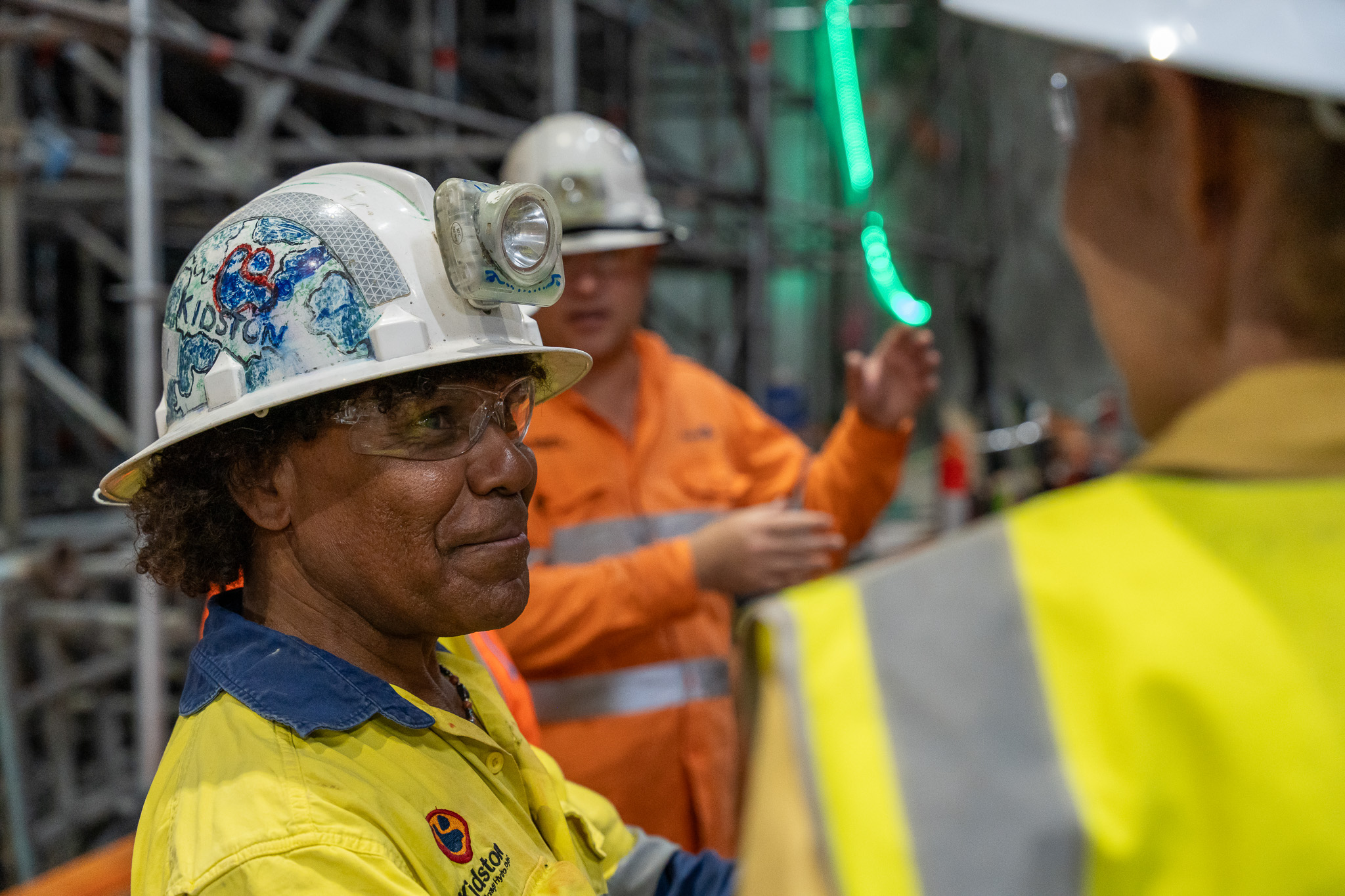 Ross Rosas speaking to supervisor underground at the Genex Kidston Pumped Storage Hydro Project with safety PPE helmet, light, hi-vis shirt and glasses